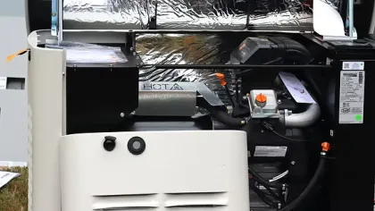 Open view of a residential standby generator showing internal components and reflective insulation panels