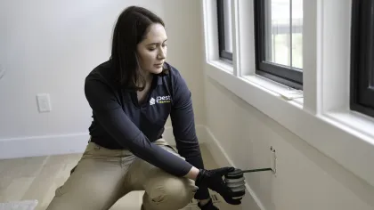 a woman sitting spraying into an outlet