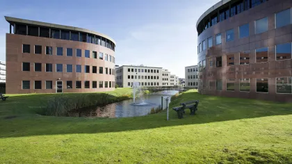 a large building with a pond in front of it