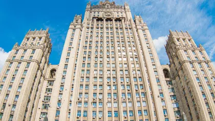 Tall historic government building with intricate architectural details under a bright blue sky with scattered clouds