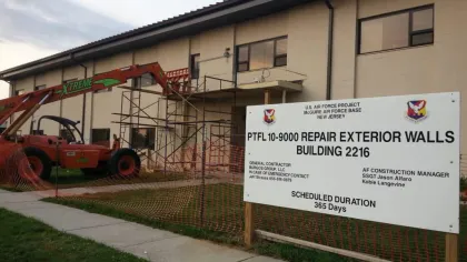 Construction equipment and scaffolding outside building 2216 at McGuire Air Force Base for exterior wall repairs.