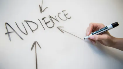 a hand writing on a whiteboard