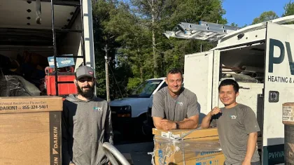 a group of men standing next to a truck