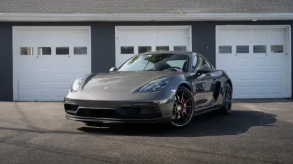 a silver sports car parked in front of a garage