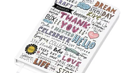 White journal cover with colorful inspirational words and doodles like thank you, dream, love, and life.