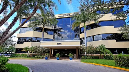 West Boca Medical Arts Pavilion building with palm trees and clear blue sky in Florida.