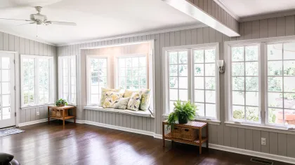 a room with a wood floor and windows with a wood floor and a wood floor with a table
