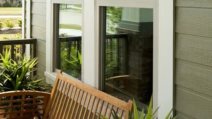 a deck with a chair and a table in front of a window