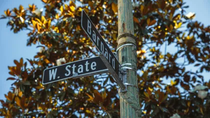 Intersection of Barnard Street and West State Street with a weathered pole and leafy trees in background.