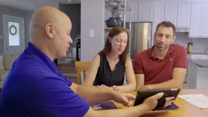 people sitting at a table looking at a tablet