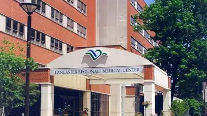 Entrance of Lancaster Regional Medical Center with building, trees, and lamp post on a sunny day
