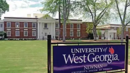 University of West Georgia Newnan campus building with large sign and green lawn under blue sky