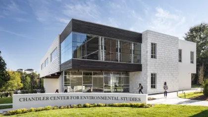 Modern Chandler Center for Environmental Studies building with glass and stone facade under blue sky.