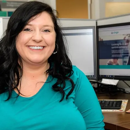 a woman smiling in front of a computer