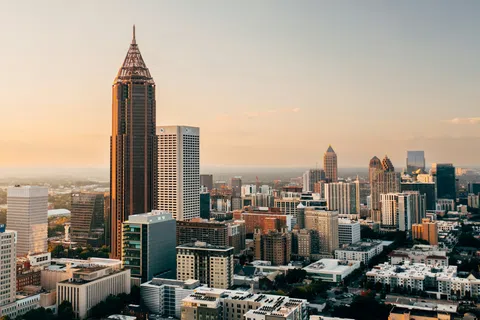 Downtown Atlanta skyline at sunset with prominent skyscrapers and urban buildings under a clear sky.