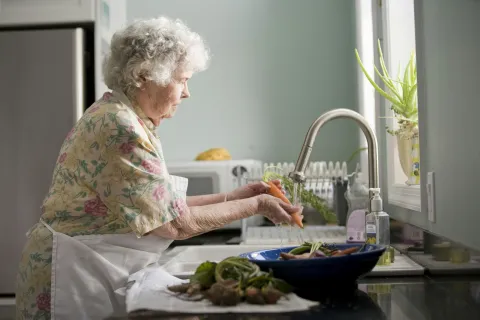 an old woman washing dishes