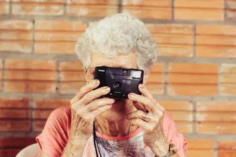 an older woman holding a camera