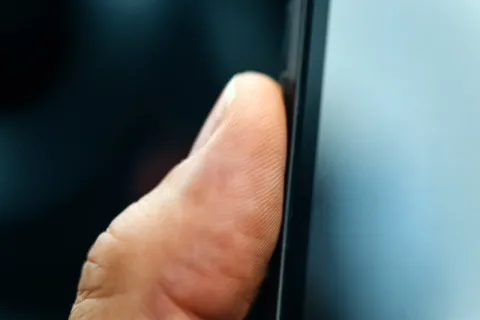 a finger pressing on a screen