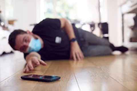 a person lying on the floor with a cell phone