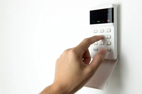 a hand controlling a security system