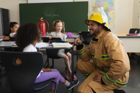 a firefighter in front of a group of children
