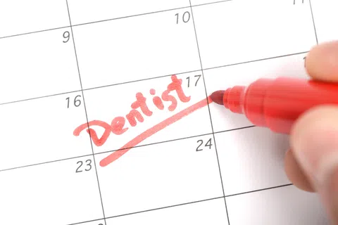 Close-up of calendar with the word Dentist written and underlined in red marker on the 17th