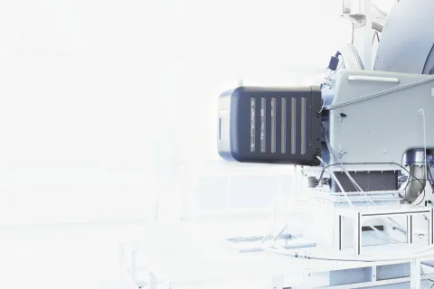 Close-up of industrial machinery with metallic components in a bright, white background environment