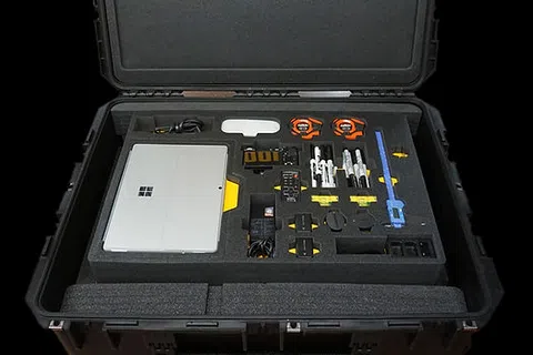 Open ToolKeepers Mobile Precision Kit case showing organized compartments and tools including a Microsoft Surface device.