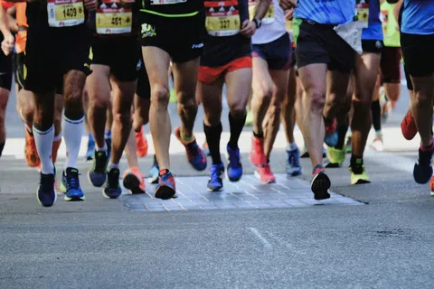 Close-up of marathon runners' legs and feet on a city street during a race event.