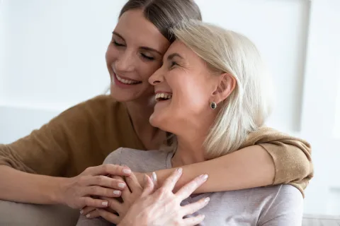 a woman kissing another woman's cheek