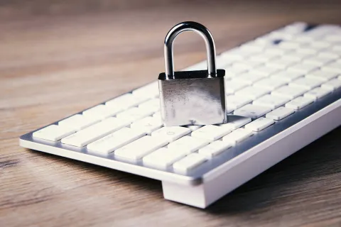 Metal padlock placed on a white computer keyboard symbolizing CyberWatch computer security
