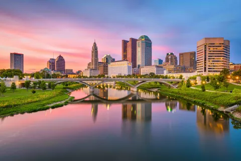 a bridge over a river with a city in the background