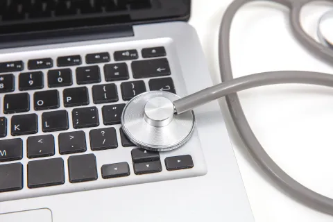 Stethoscope placed on laptop keyboard symbolizing computer diagnostics and IT health monitoring
