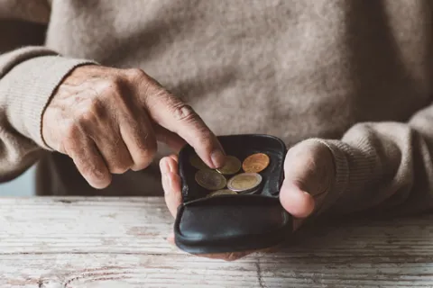 a person holding a black device with coins on it