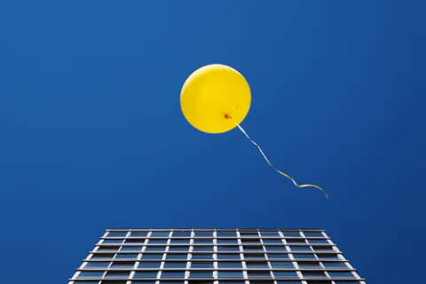 a yellow balloon floating over a solar panel