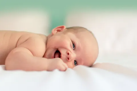 a baby lying on a bed