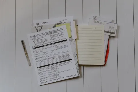 a white board with tax papers and a pen on it