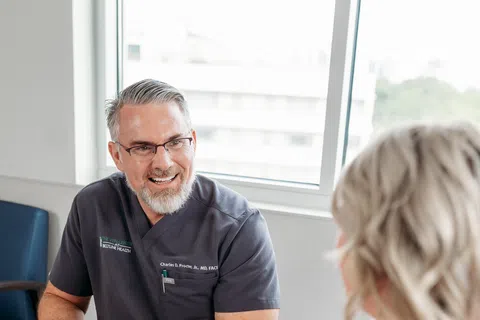 Vein specialist consulting with a patient about morning leg heaviness, a possible sign of chronic venous insufficiency, at Beltline Health.