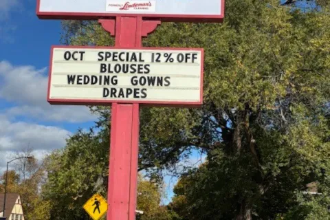 Martinizing Cleaners sign advertising 12% off blouses, wedding gowns, and drapes for October special.