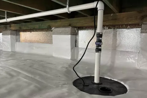 Clean and well-maintained crawl space with plumbing and waterproofing features.