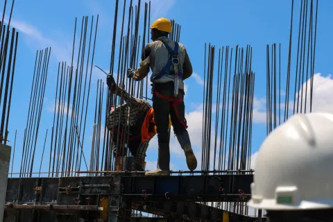 a man wearing a hard hat and climbing a metal structure