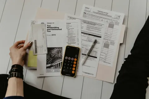 a person holding a phone and a newspaper