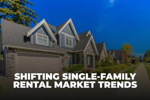 Modern single-family homes in a suburban neighborhood with clear skies and green lawns.