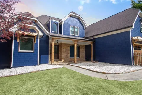 a blue house with siding on a sunny day