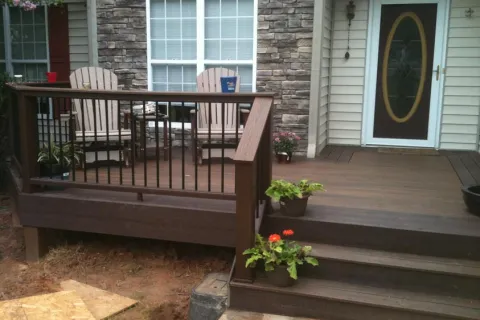 Elegant outdoor deck with seating, flower pots, and inviting entrance, perfect for relaxation.