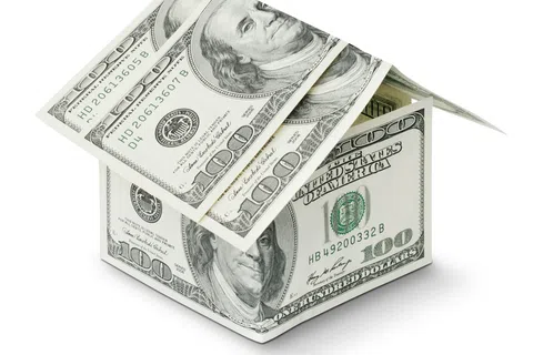 House model made of folded 100 dollar bills symbolizing financial investment in real estate.