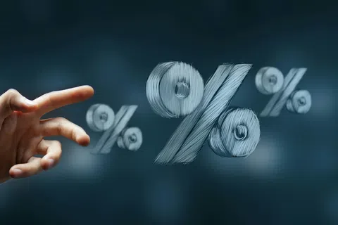 Hand pointing at floating percentage symbols representing finance, interest rates, and discounts in blue tones.
