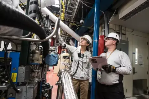 Engineers inspecting machinery in a modern industrial facility, focused on safety and efficiency.
