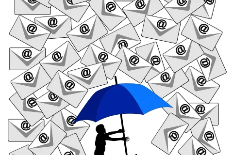 Silhouette of person holding blue umbrella shielding from a flood of email envelopes with at symbols.