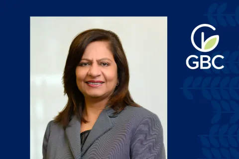 Professional woman in business attire smiling against a light background with GBC logo on navy blue border